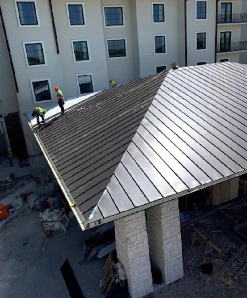 Crew installing standing seam metal roof panels on a commercial project in Las Vegas
